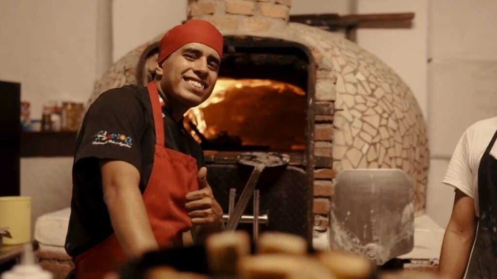 florios puerto vallarta cook in front of brick oven giving a thumbs up