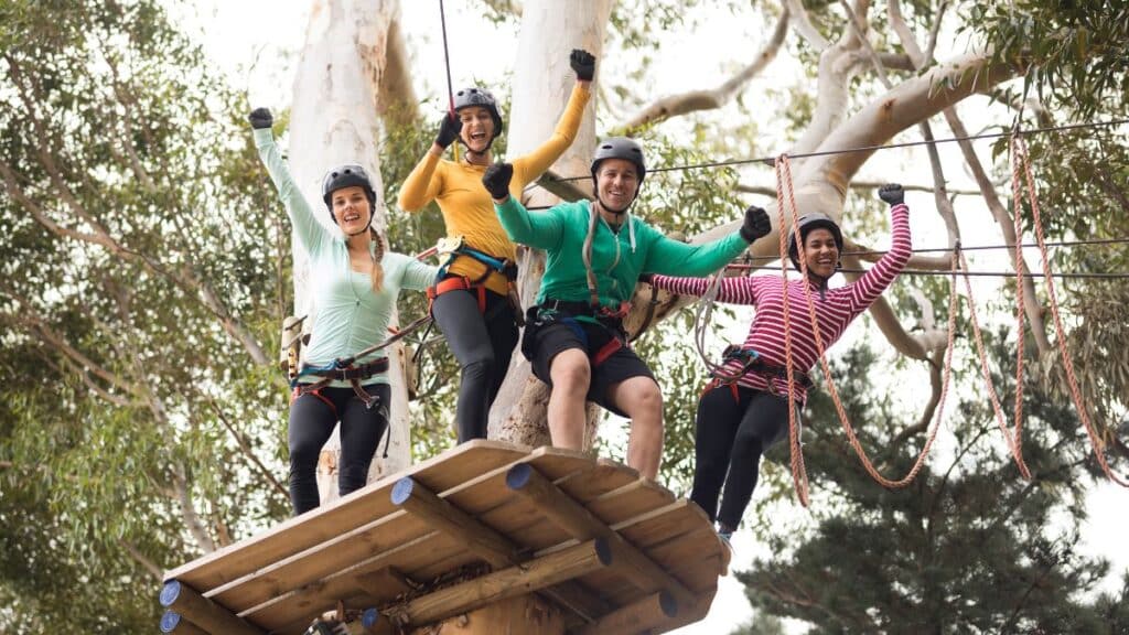 friends enjoying zip line adventure in park on a sunny day