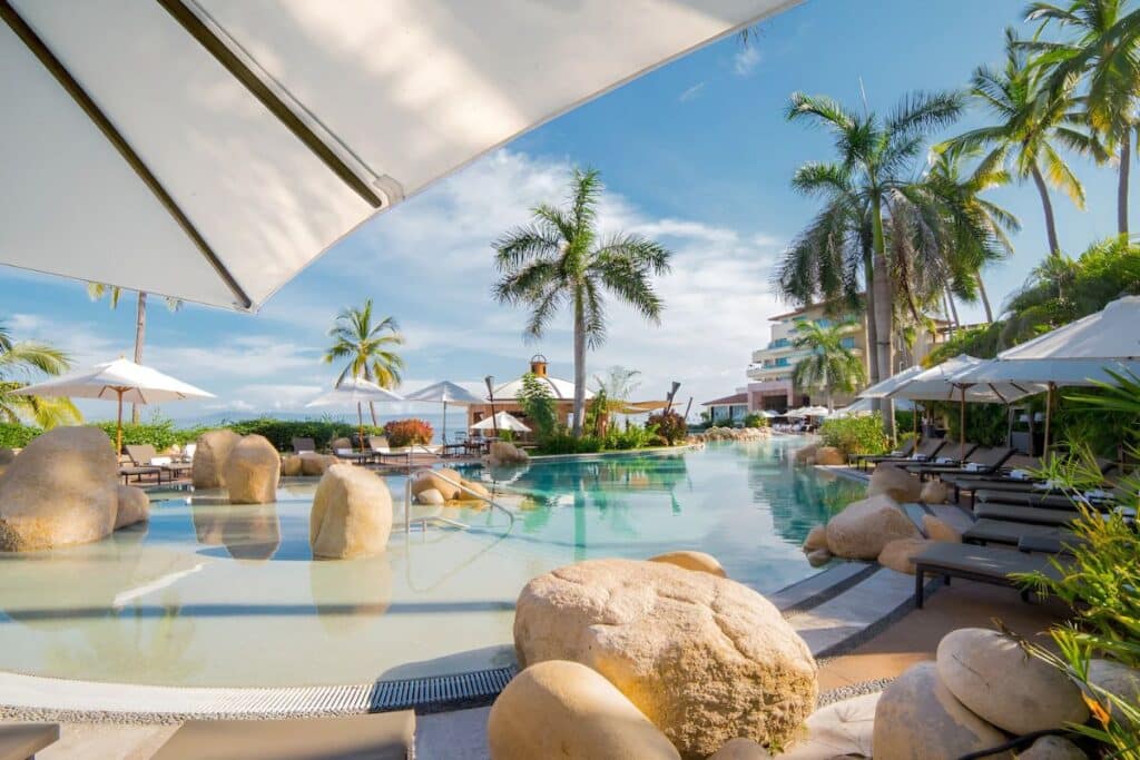 garza blanca outdoor pools palm trees and sun loungers on a sunny day