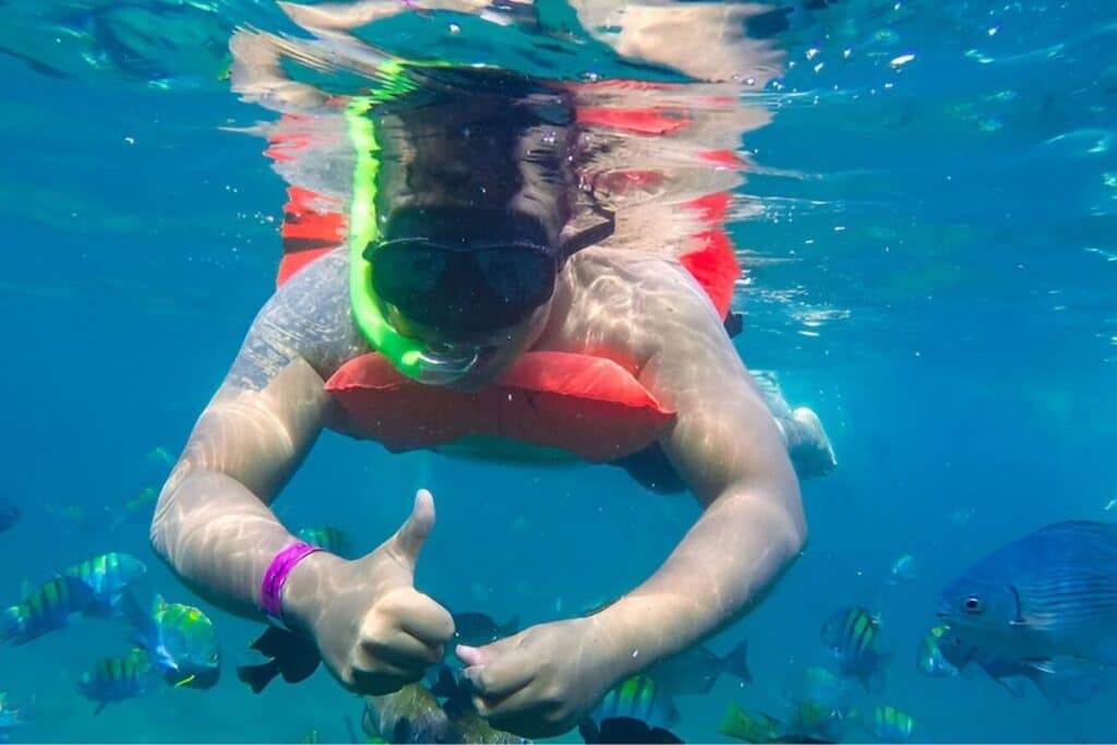 tattooed man scuba diving giving a thumbs up