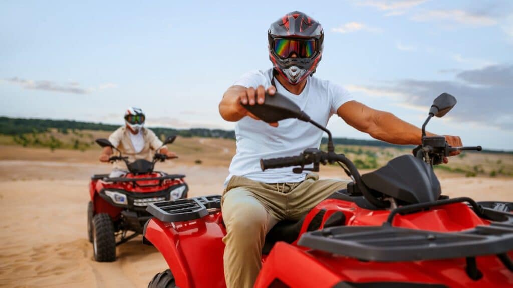 two atv riders racing in dune safari on a hot summer day