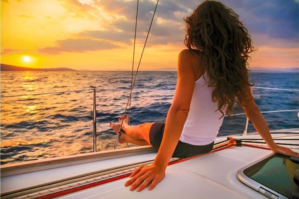 beautiful woman basking in the sunset on a yacht deck