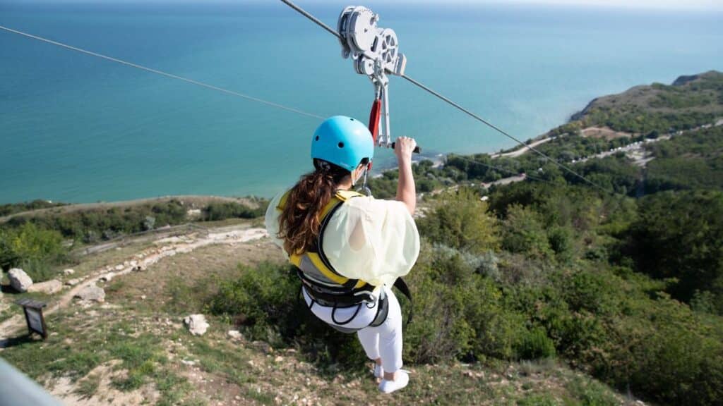 woman on zipline with ocean background 
