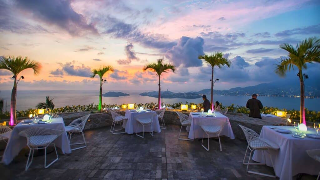 las brisas acapulco elegant outdoor dining area with lit palm trees at sunset