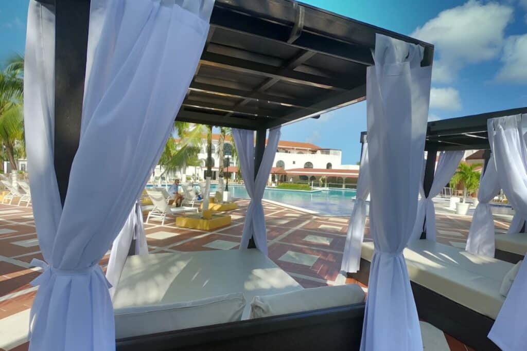 beach cabanas overlooking the outdoor pool and palm trees