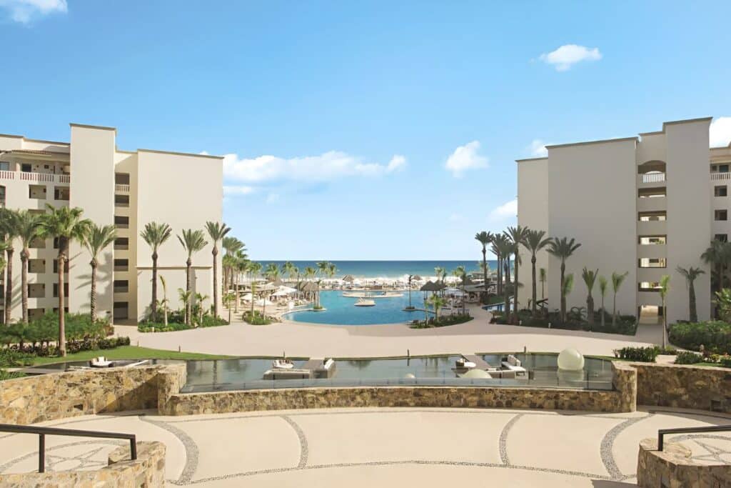 immaculate courtyard with outdoor pool and bay in the background
