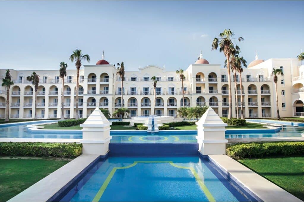 resort courtyard with an elegant fountain surrounded by palm trees