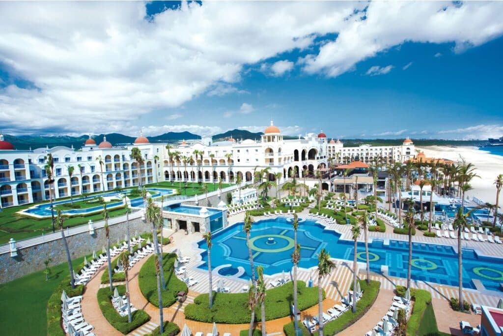 majestic aerial view of riu palace cabo san lucas with mountains in background