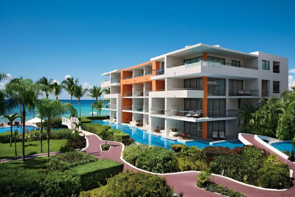 secrets aura cozumel hotel at the beach surrounded by palm trees