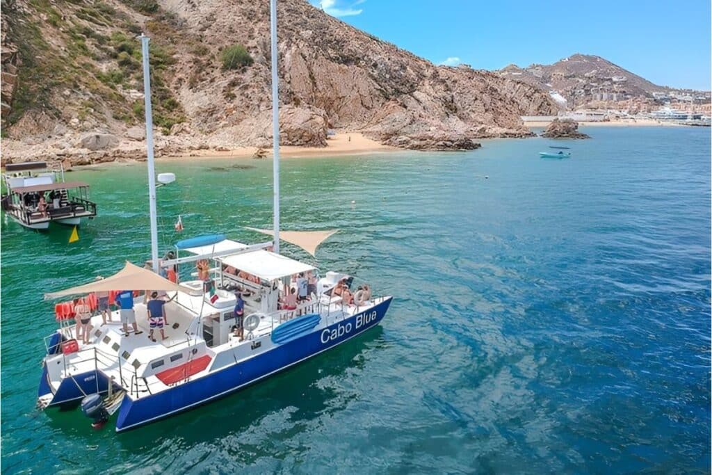 two catamarans in the bay with mountains in the background