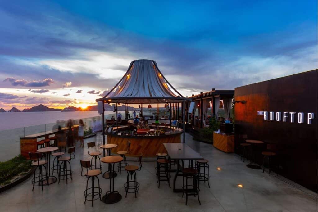 rooftop terrace restaurant with a sunset behind the mountains